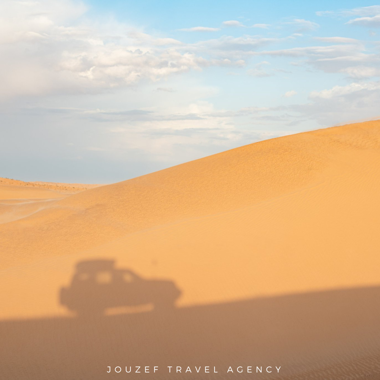 Shadow of a 4x4 vehicle cast over the sand dunes a desert tour near Douz, Tunisia