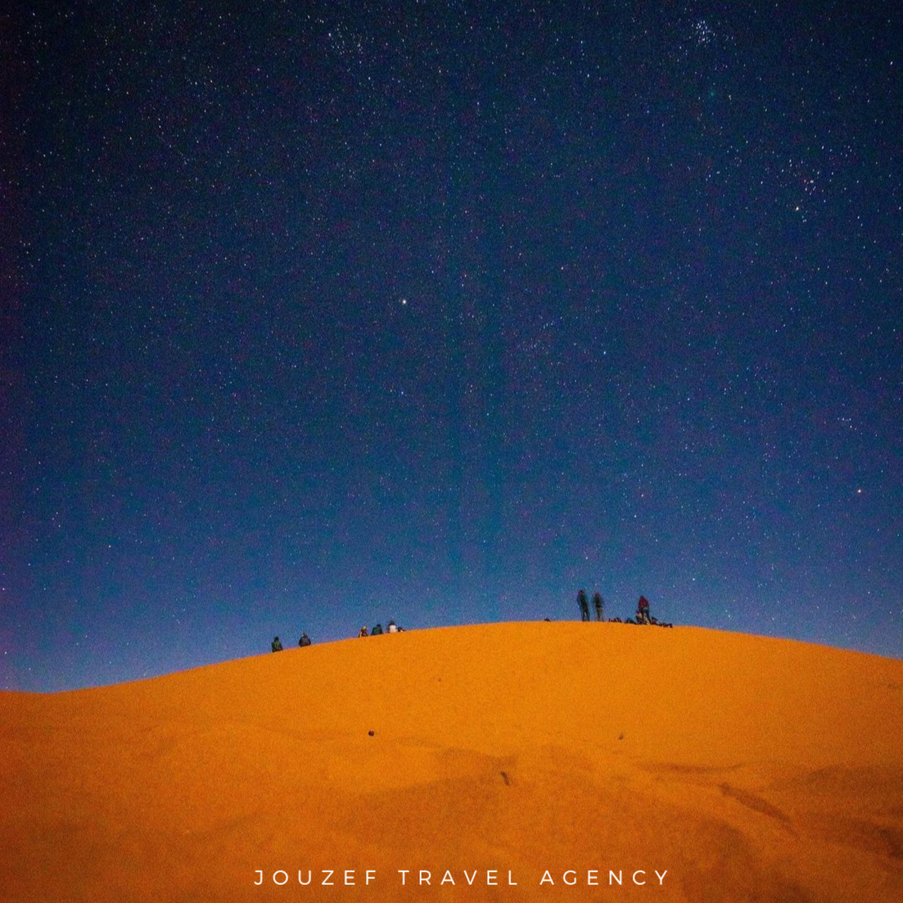 People stargazing on sand dunes after sunset during a desert tour in Douz, Tunisia